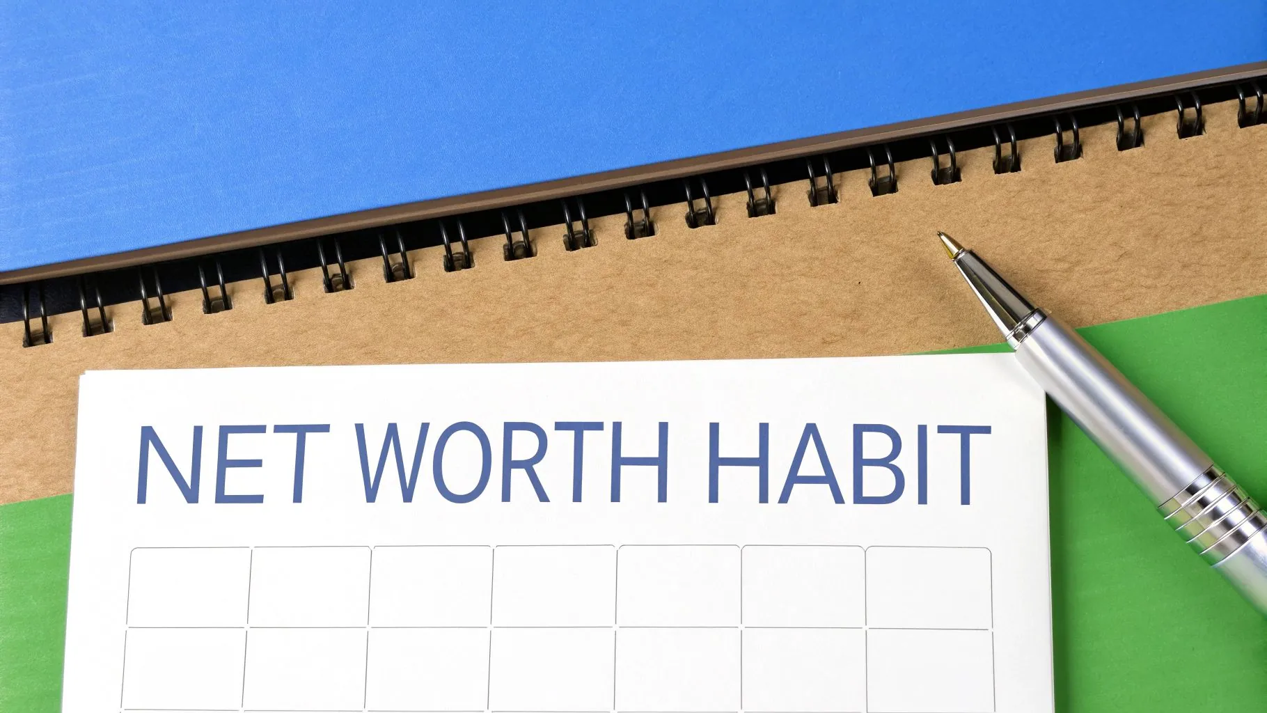 A person marking their financial progress on a calendar, symbolizing the habit of tracking net worth.
